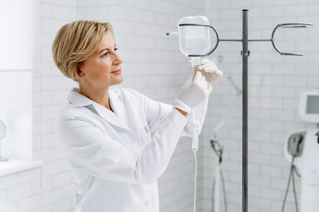 careful-senior-nurse-is-standing-near-drop-counter-clinic-preparing-invasion-medicine-healthcare-concept
