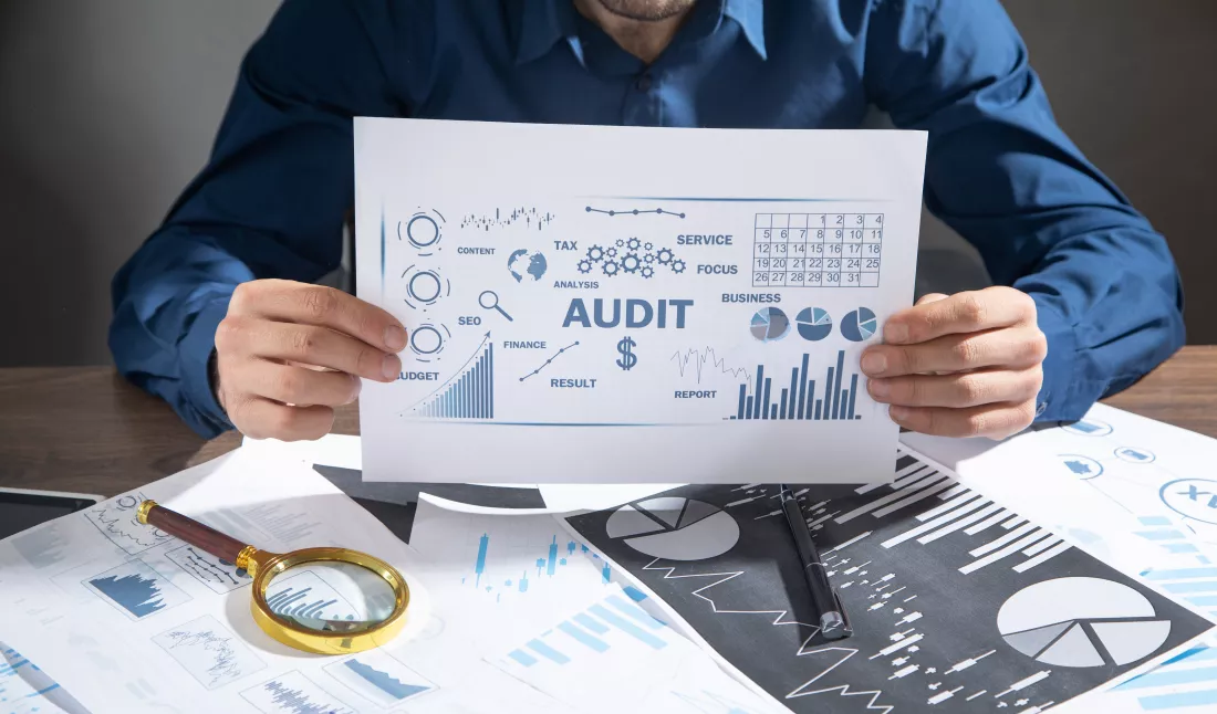 man-showing-audit-business-charts-with-words