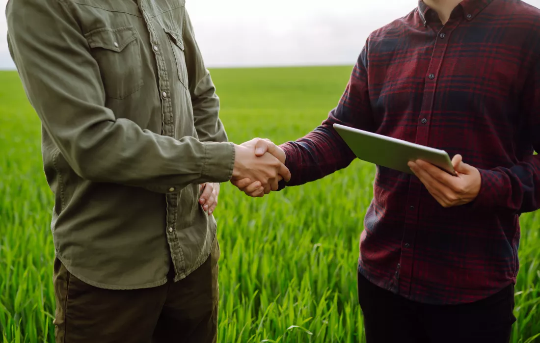 two-farmers-making-agreement-with-handshake-green-wheat-field-agricultural-business