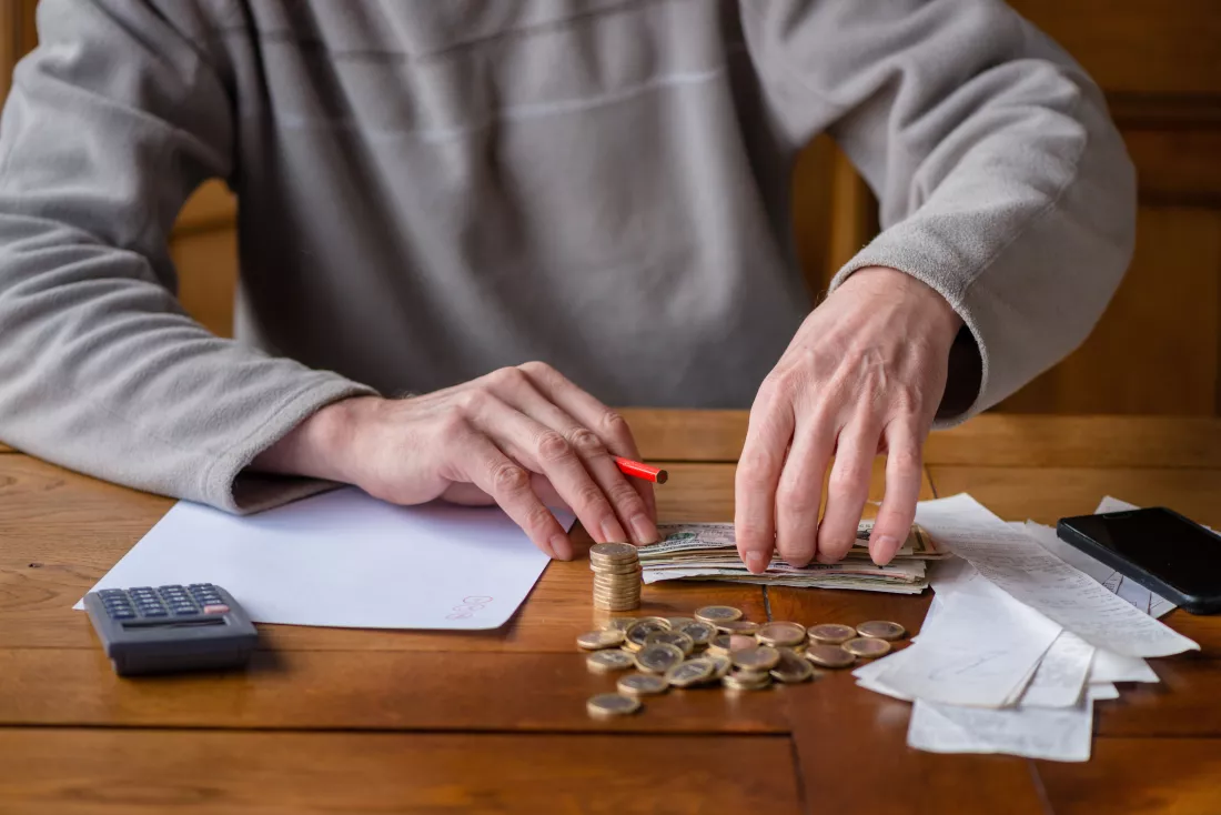 midsection-man-calculating-money-table