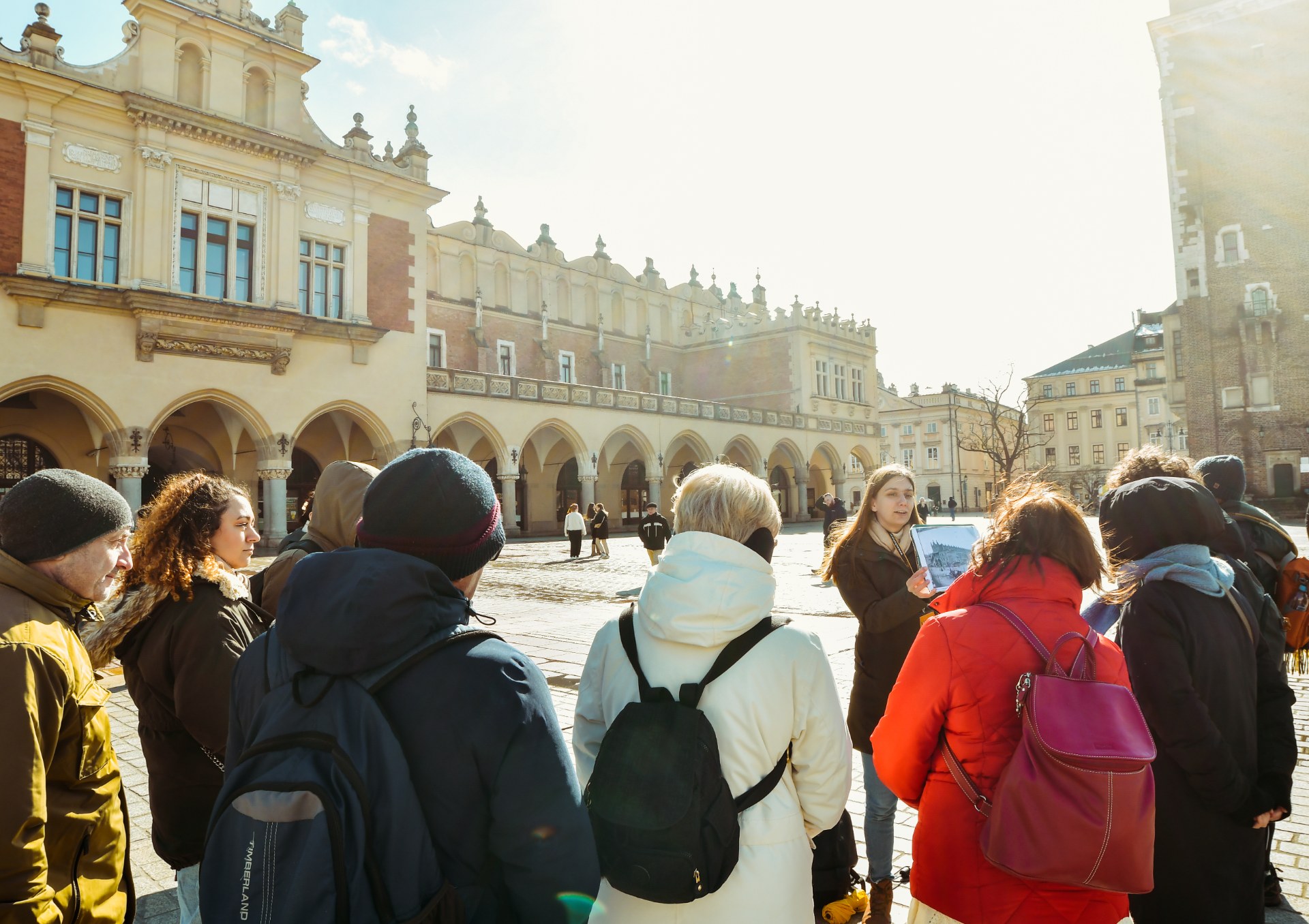 A group of young people with a guide on the Main Market Square in Krakow