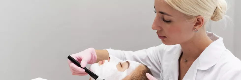 Cosmetology-test-professional-beautician-applies-white-cosmetic-cream-to-a-gi