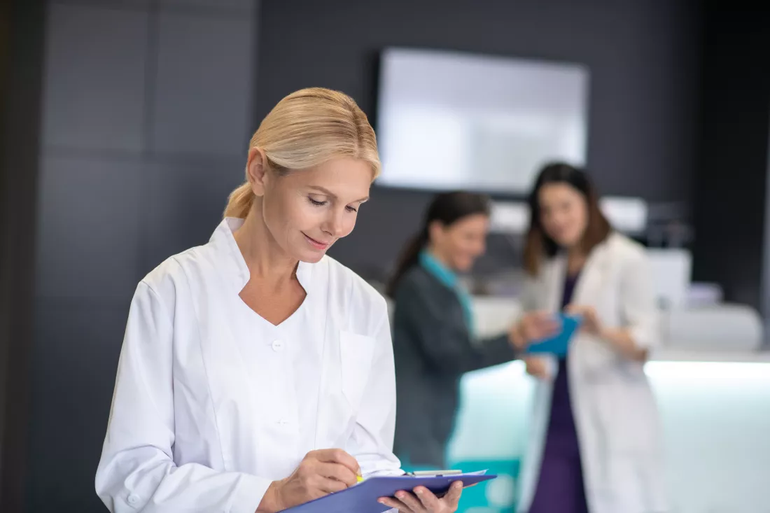 mature-blonde-doctor-wearing-white-robe-looking-busy