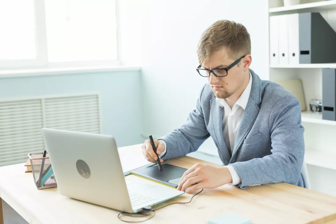 young-man-using-mobile-phone-while-sitting-table