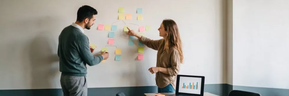 managers-arranging-blank-sticky-notes-into-a-process-map