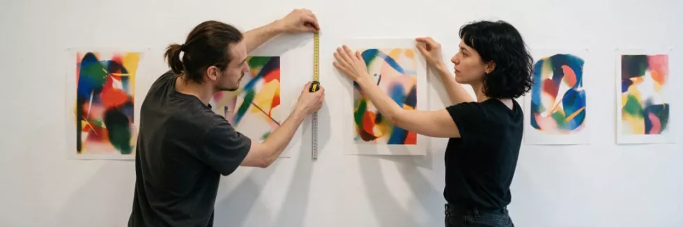 artists-hanging-prints-in-an-exhibition-space