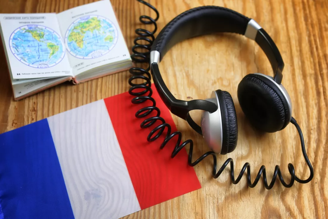 language-course-headphone-flag-wooden-table