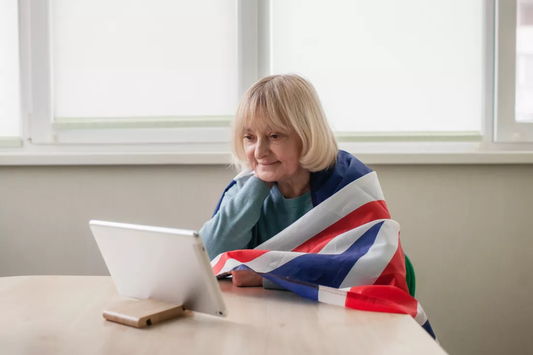 woman-with-british-flag-watches-broadcast-platinum-jubilee-queen-celebrations-online-home