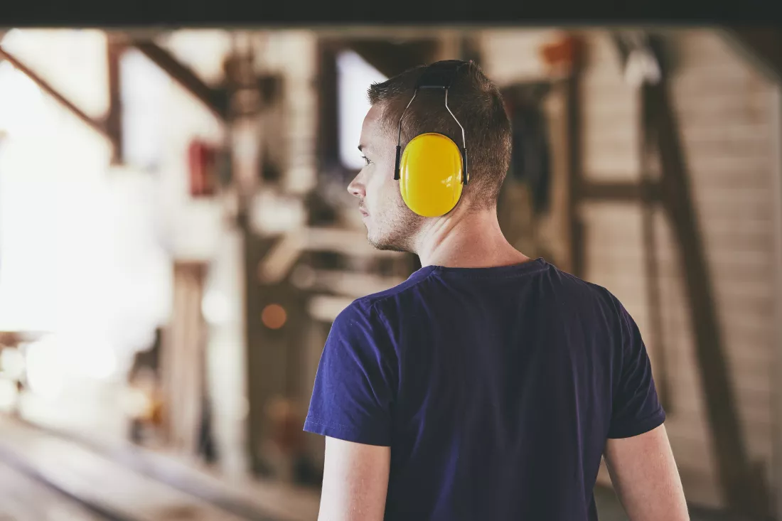 rear-view-worker-wearing-protective-headphones