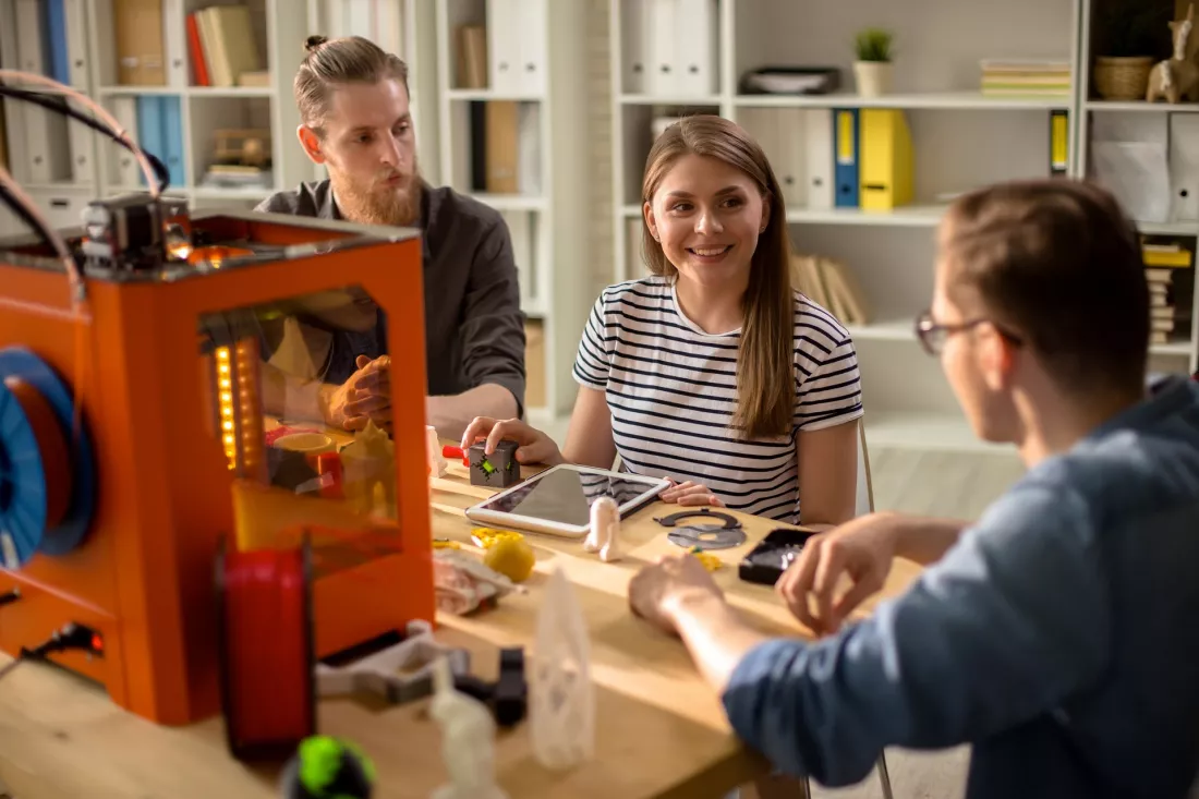 Design students working with a 3D printer