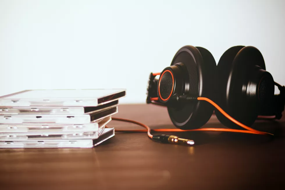 close-up-headphones-stacked-compact-discs-table